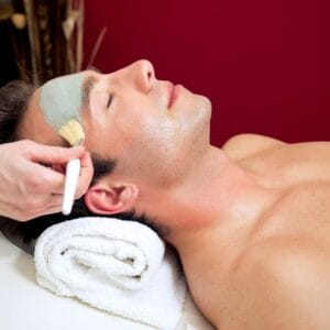 A man getting his face waxed at the spa