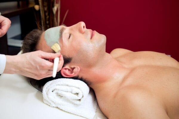 A man getting his face waxed at the spa