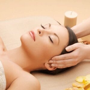 A woman getting her head touched by an esthetician.