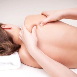 A person is getting their back examined by an acupuncturist.